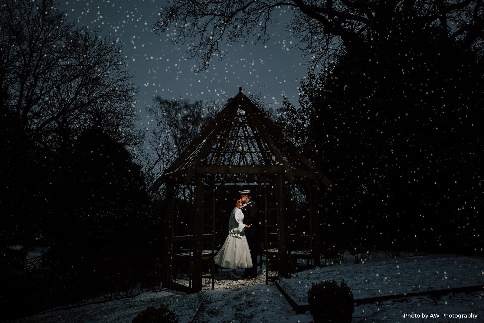 Danielle and Dan under the gazebo outside with snow. Photo by AW Photography/