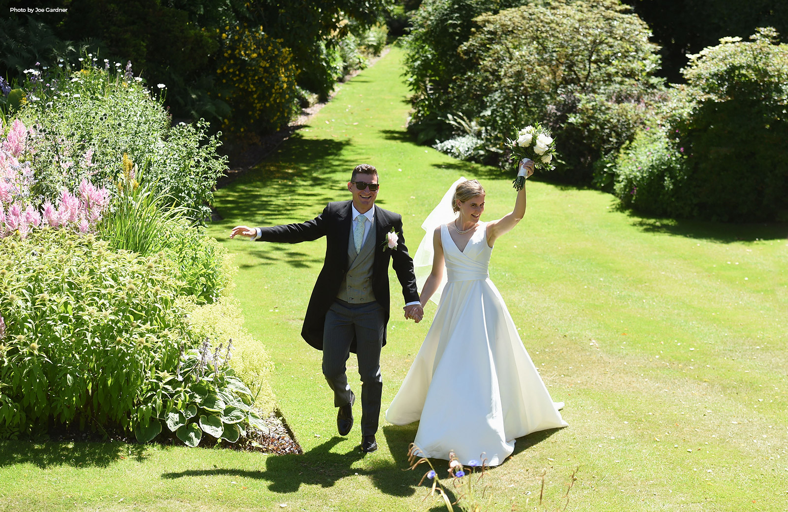 Bride and Groom walking through the sunlight gardens at Hilltop Country House.